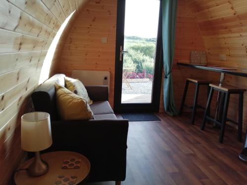 a living room with a couch and a table at Portnalong Pod in Port na Long
