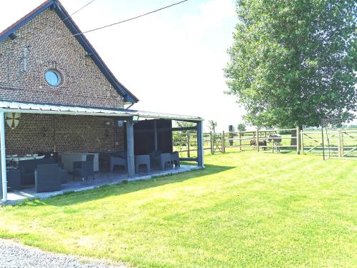 a building with chairs in a field next to a fence at Le Domaine du Templier - Chapelain in Borre