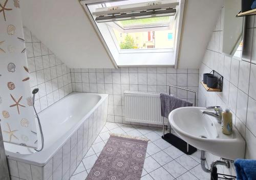 ein Badezimmer mit einer Badewanne und einem Waschbecken in der Unterkunft FEWO Schinkestrasse in Bad Schandau