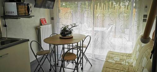 a small table and chairs in a kitchen with a window at STUDIO MEZZANINE 2/3 Personnes in La Teste-de-Buch