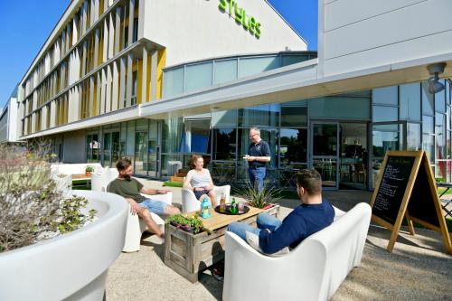 a group of people sitting in chairs outside of a building at ibis Styles Nantes Reze Aéroport in Rezé
