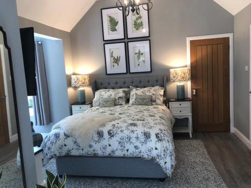a bedroom with a bed and two night stands and two lamps at Buccleuch Garden Room in Fort William