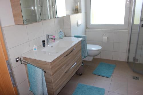 a bathroom with a sink and a toilet at Ferienwohnung Am Sonnenhang Blecher in Bad Laasphe