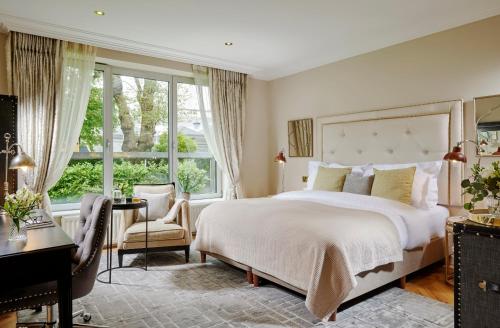 a bedroom with a large bed and a desk and window at Great Southern Killarney in Killarney