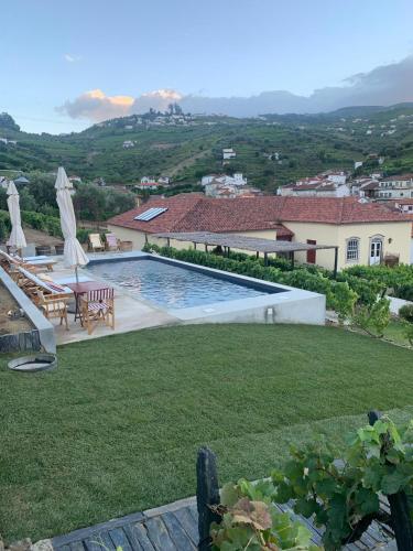 a backyard with a swimming pool and a house at Quinta da Casa Amarela- Casas da Quinta - Turismo em Espaço Rural in Lamego