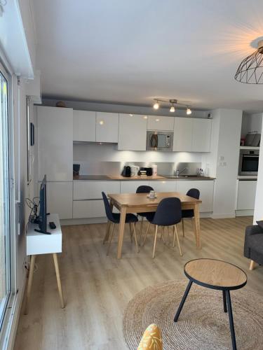 un salon avec une table et une cuisine dans l'établissement Appartement cosy plein centre à 2 pas de la plage, à Le Touquet-Paris-Plage