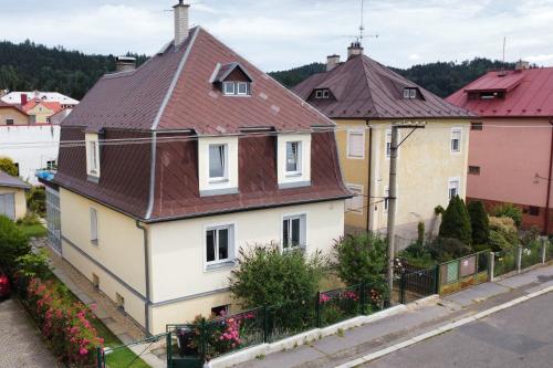une maison blanche avec un toit marron dans l'établissement Pension u Šťastných, à Mariánské Lázně