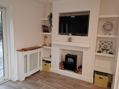 a living room with a fireplace and a flat screen tv at The Loft in Crossmolina