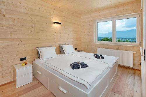 a bedroom with a white bed in a wooden wall at Haus Deutz in Oberaichwald