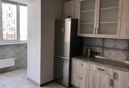 a kitchen with a stainless steel refrigerator and a window at Apartments & Vernissage on Kostandi in Odesa