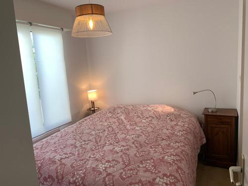 una camera da letto con un letto, una lampada e una finestra di Appartement cosy plein centre à 2 pas de la plage a Le Touquet-Paris-Plage