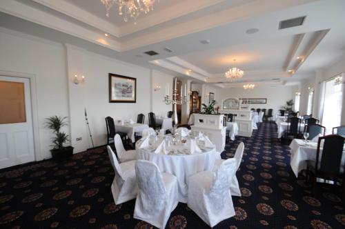a banquet room with white tables and chairs at Bay View Hotel in Killybegs