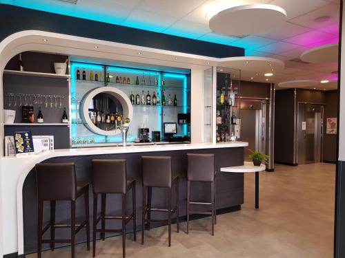 un bar dans un hôtel avec tabourets et comptoir dans l'établissement B&B HOTEL Béthune Bruay-la-Buissière, à Bruay-la-Buissière