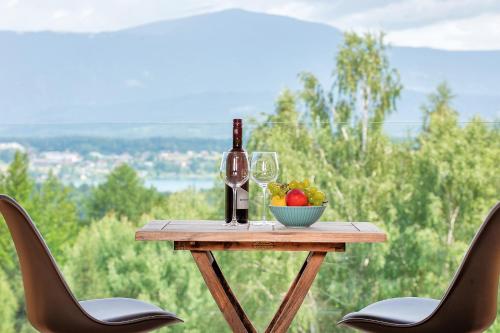 a table with a bottle of wine and a bowl of fruit at Das Deutz in Oberaichwald