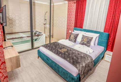 Hotel Sonoma في Kosovo Polje: غرفة نوم مع سرير مع حوض استحمام فيه