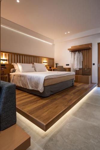 a bedroom with a large bed and wooden floors at Sivota Kipoi Design Suites in Syvota