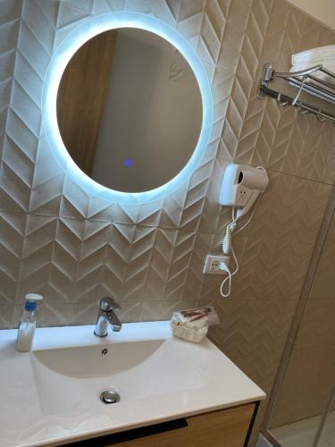 baño con lavabo y espejo en la pared en B&B Torre Pozzillo, en Cinisi