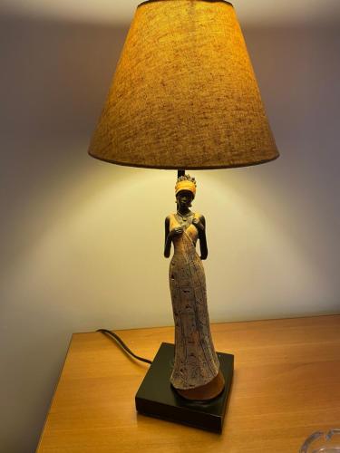 a statue of a woman sitting on a table with a lamp at B&B Torre Pozzillo in Cinisi