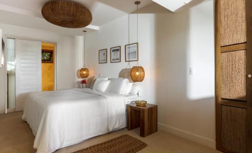 a white bedroom with a bed and a table at Villa Praia - La Villa Group in Jericoacoara