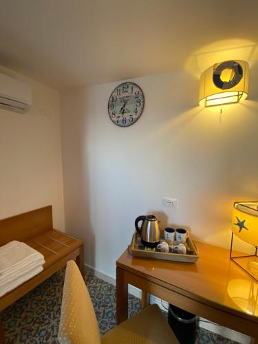 a room with a table and a clock on the wall at B&B Torre Pozzillo in Cinisi