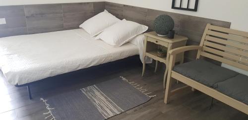 een slaapkamer met een bed, een stoel en een bank bij Chanot Le Studio cour parking et piscine in Marseille