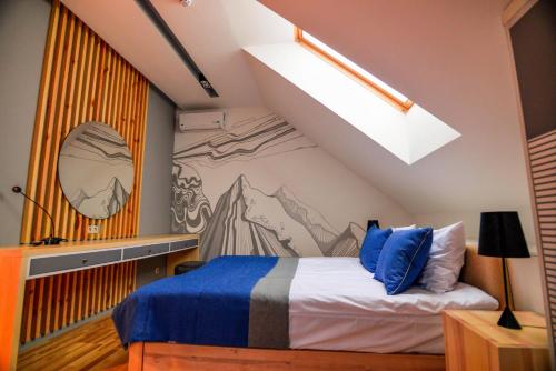 a bedroom with a bed with a mountain mural on the wall at Трипільське Сонце in Podgortsy