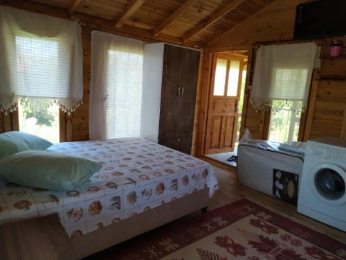 a bedroom with a bed and a washing machine at Gulseven Bungalow Villas in Dalaman