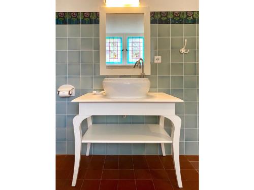 ein Bad mit einem Waschbecken und einem Spiegel in der Unterkunft FeWo Art Deco in Zittau