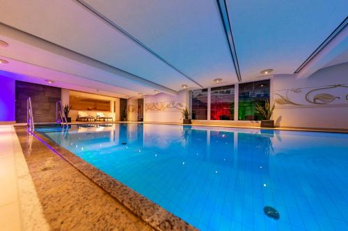 蒂羅爾州塞弗爾德的住宿－澤費爾德百樂酒店，大楼内一个蓝色的大型游泳池