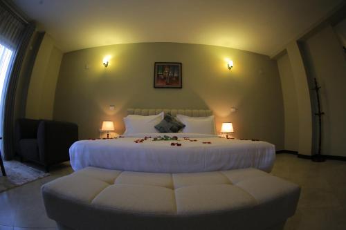 a bedroom with a large bed and a couch at Daisy Hotel in Addis Ababa
