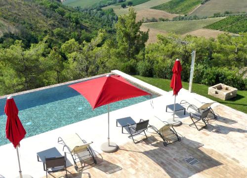 a swimming pool with chairs and umbrellas next to a pool at Relais Cocci Grifoni - Panoramic Wine Resort in Offida