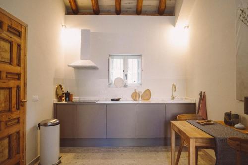 a kitchen with a counter and a table and a window at Ronda City Wall Apartments with Private Pool in Ronda