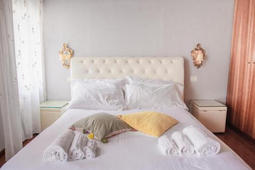 a bedroom with a white bed with towels on it at Appartamenti Superior in Via Garibaldi by Bricola Apartments in Venice
