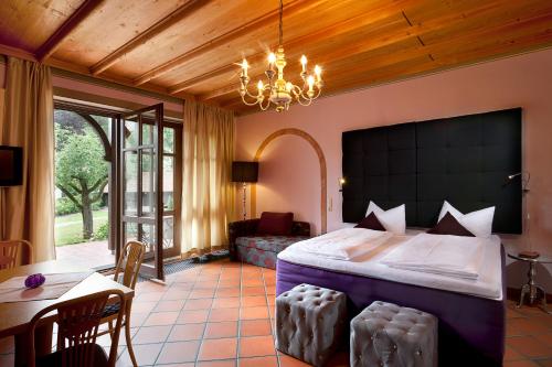 a bedroom with a bed and a table and a couch at Villa Fantasia Budget Boutique Hotel in Füssen