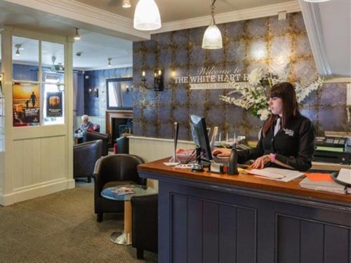 a woman sitting at a counter with a laptop at White Hart Hotel in St Austell