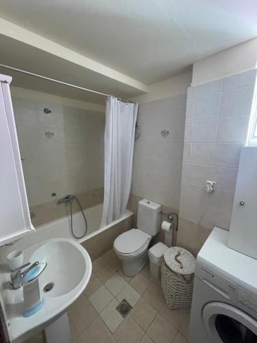 een badkamer met een wit toilet en een wastafel bij Ouranias Guesthouse in Chania