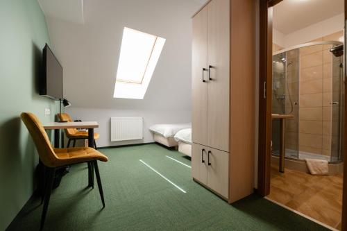 um quarto com uma cama e uma secretária com uma cadeira em Szumi Las Events & Apartments em Regimin