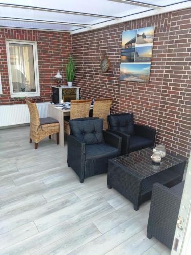 a patio with furniture and a brick wall at Ferienhaus Emden Zur Mühle Nordseeküste in Emden