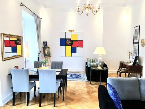 a dining room and living room with a table and chairs at MONDRIAN Luxury Suites & Apartments Market Square IV in Warsaw