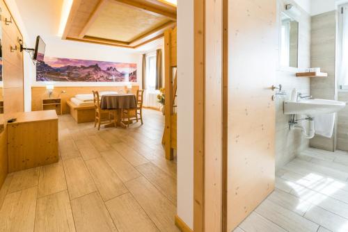 a bathroom with a sink and a dining room at Agritur Casamela in Taio