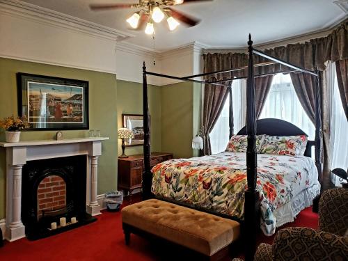 1 dormitorio con cama con dosel y chimenea en The Roses Heritage Inn en San Juan de Terranova