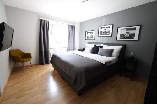 ein Schlafzimmer mit einem Bett, einem Stuhl und einem Fenster in der Unterkunft Armotti Apartments Friedheim in Bern