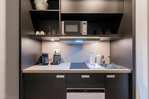 a kitchen with a sink and a microwave at Nena Apartments - Kreuzberg 61 in Berlin