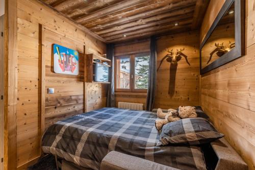 ein Schlafzimmer mit einem Bett in einer Holzhütte in der Unterkunft Flocon des Neiges in Praz-sur-Arly