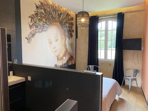 a bedroom with a large painting of a woman at Le Château de Camille in Saint-Jean-le-Comtal