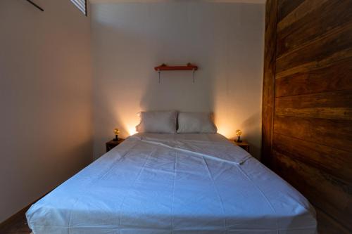 a bedroom with a bed with blue sheets and a wooden door at Santa Lova Eco-hostel Isla Tintipan in Tintipan Island