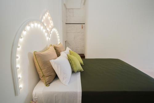 un letto bianco con quattro cuscini sopra di Casa Frea Dimora Storica a Martano