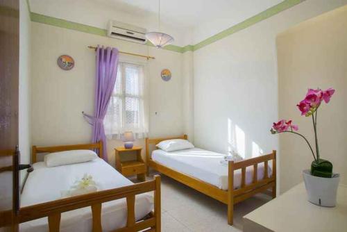 a bedroom with two beds and a window at Vitamin Sea Protaras in Protaras