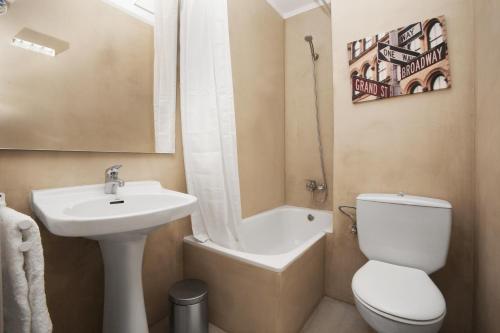 a bathroom with a sink and a toilet and a bath tub at Bcn Sagrada Familia Apartments in Barcelona