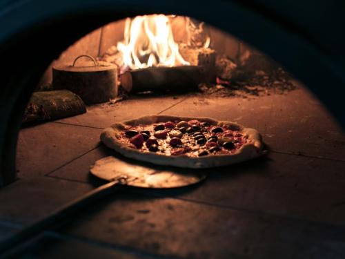 a pizza is cooking in a brick oven at The Green W7 in London